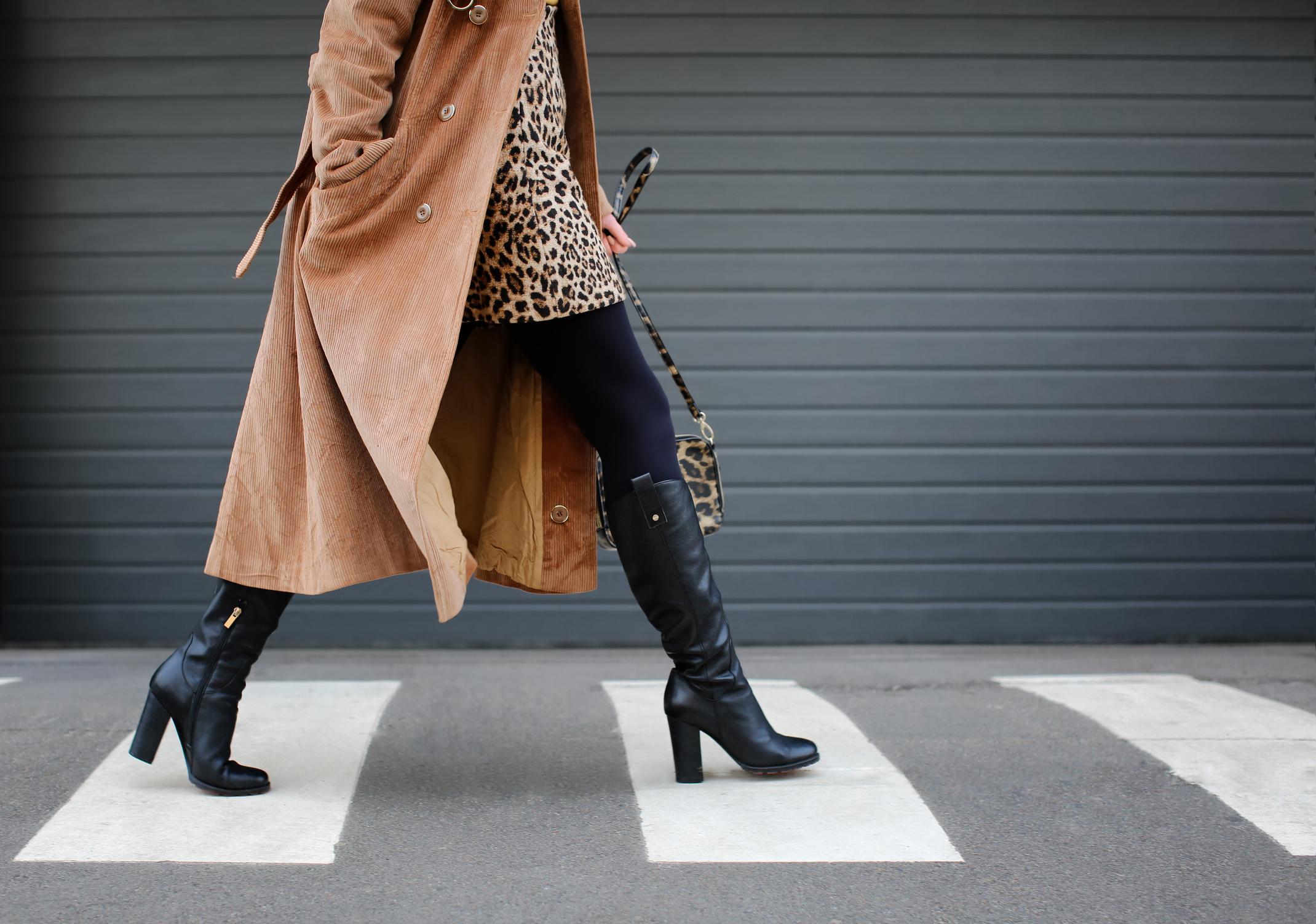 a person in a leopard print dress and coat crossing a street gift vouchers available