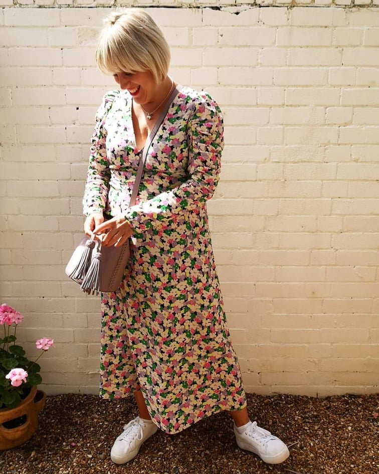 Katie Jane Styles, personal stylist in a floral dress and white sneakers