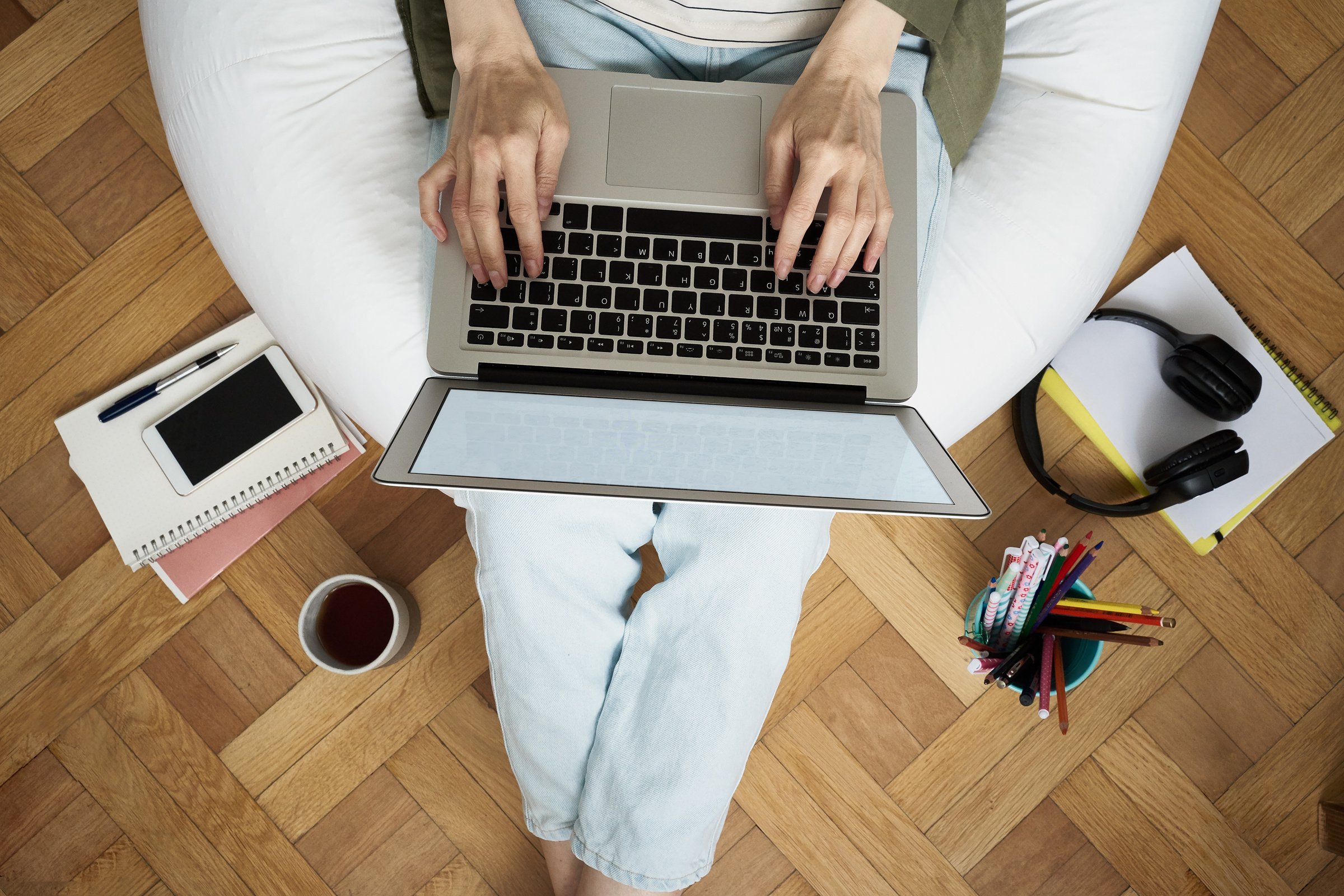 a person sitting on a bean bag with a laptop creating an online shopping style file